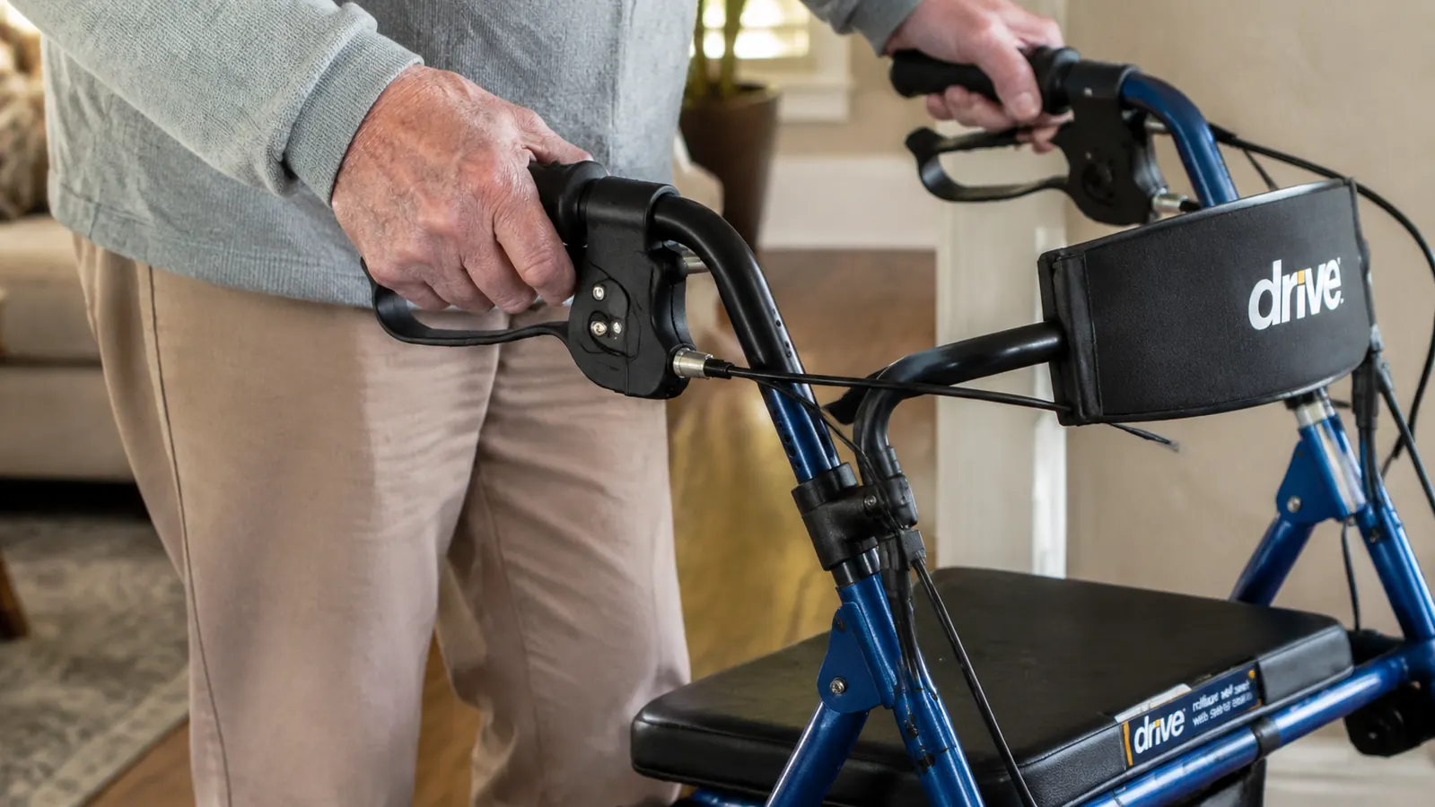 Close-up of hand squeezing the loop brake handle on a Drive Medical rollator walker