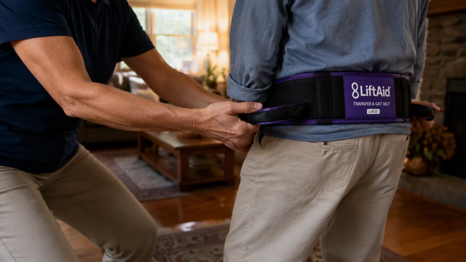 Side view showing caregiver's underhand grip on gait belt loops, feet shoulder-width apart with slight forward lean